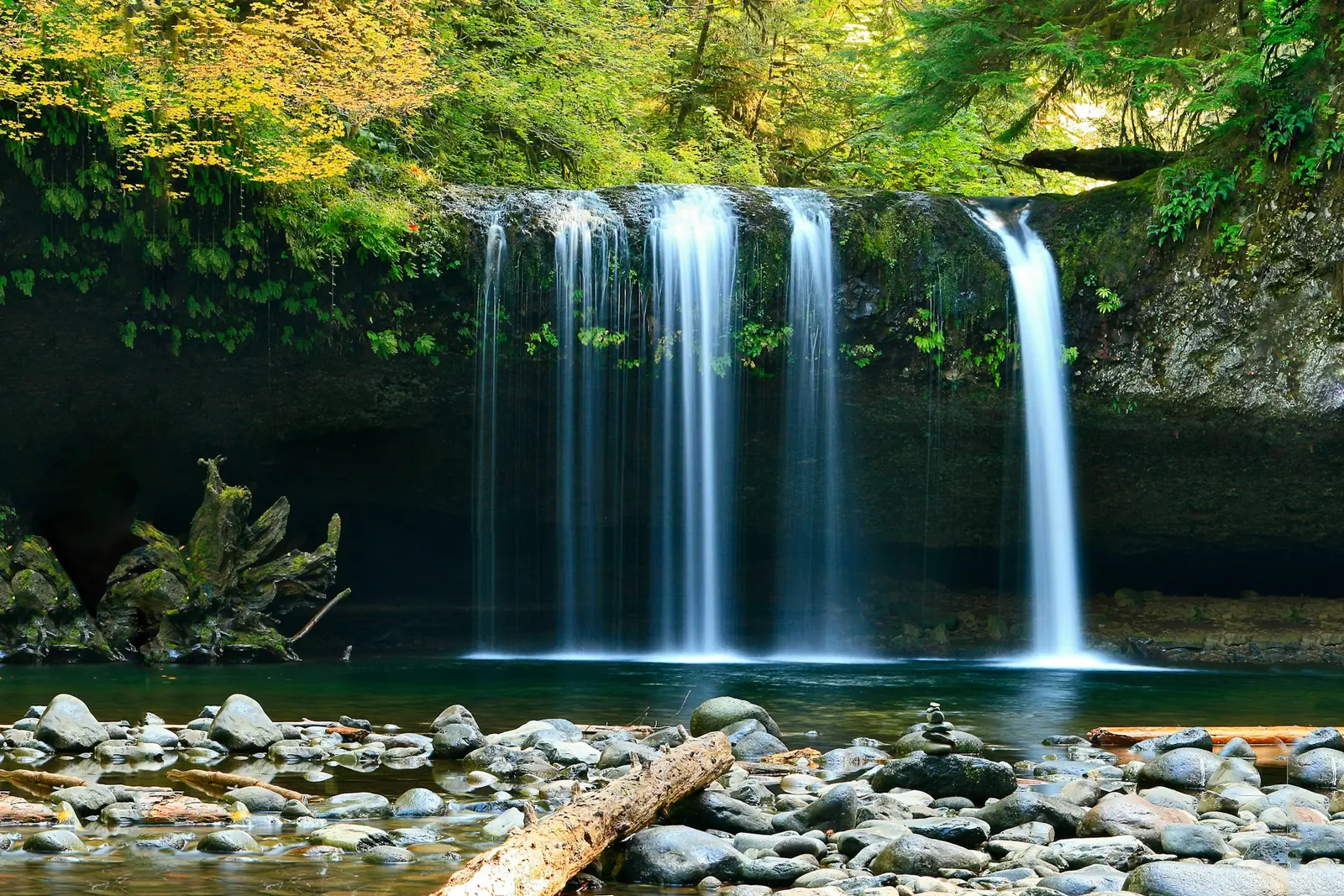 A wide waterfall dropping into a river gorge