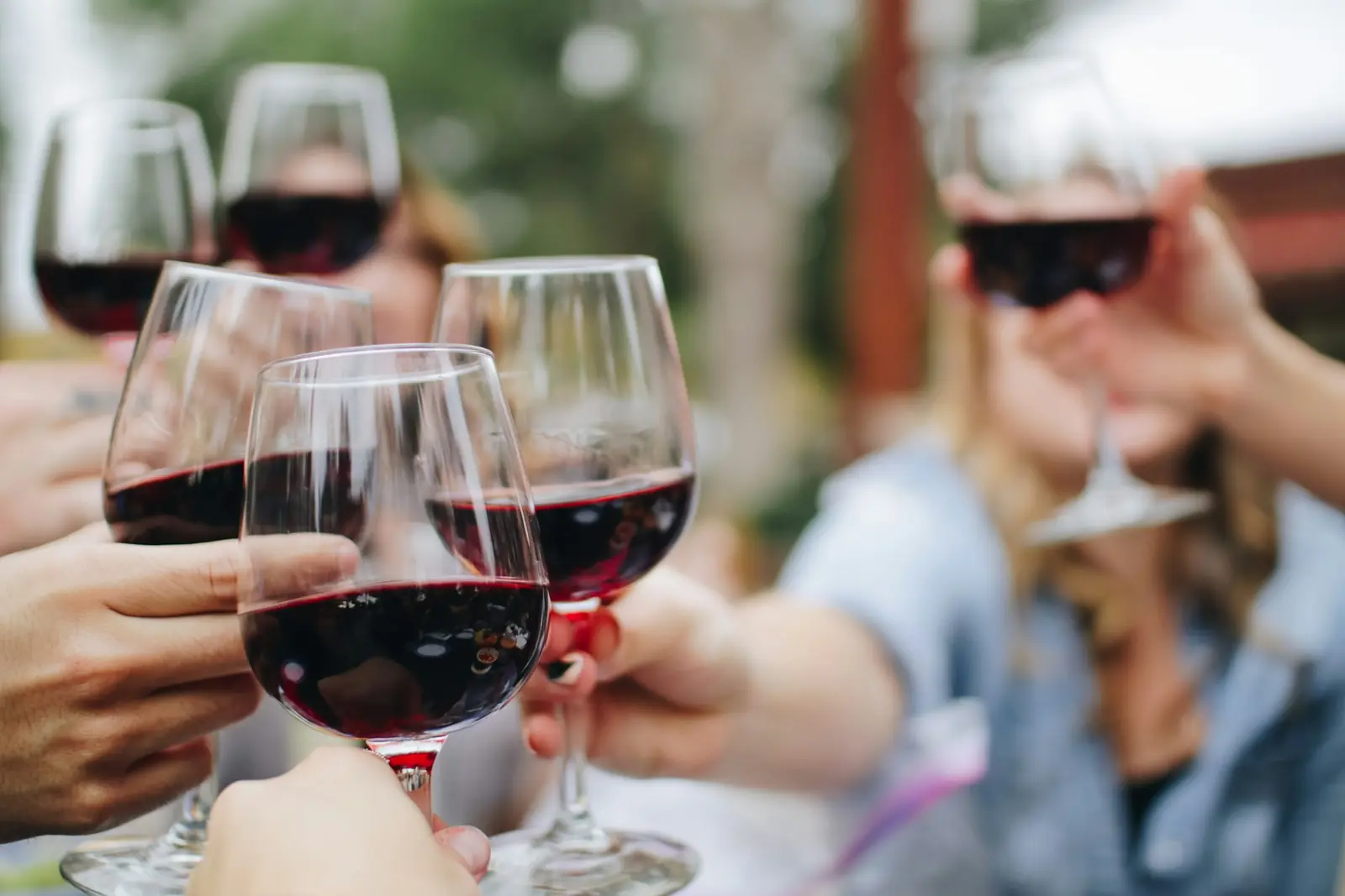 Glasses of red wine raised together outdoors